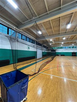 an athletic gym with a 3D rectangle suspended in the air made of black netting.